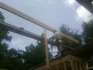 Carpenter setting a ridge beam over a new addition frame — Ice Dam Removal by Roofing Brothers in Randle
