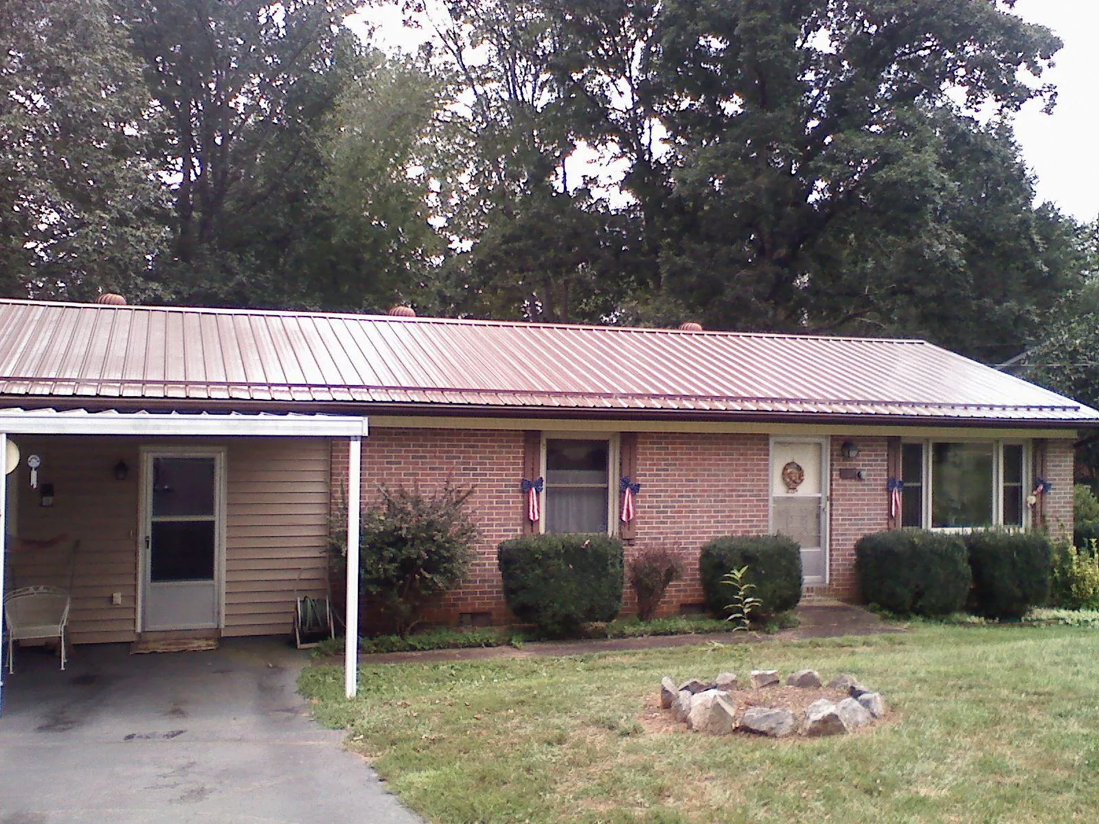 Bronze metal roof and carport on a brick ranch home — Roof Repair work by our crew in Randle