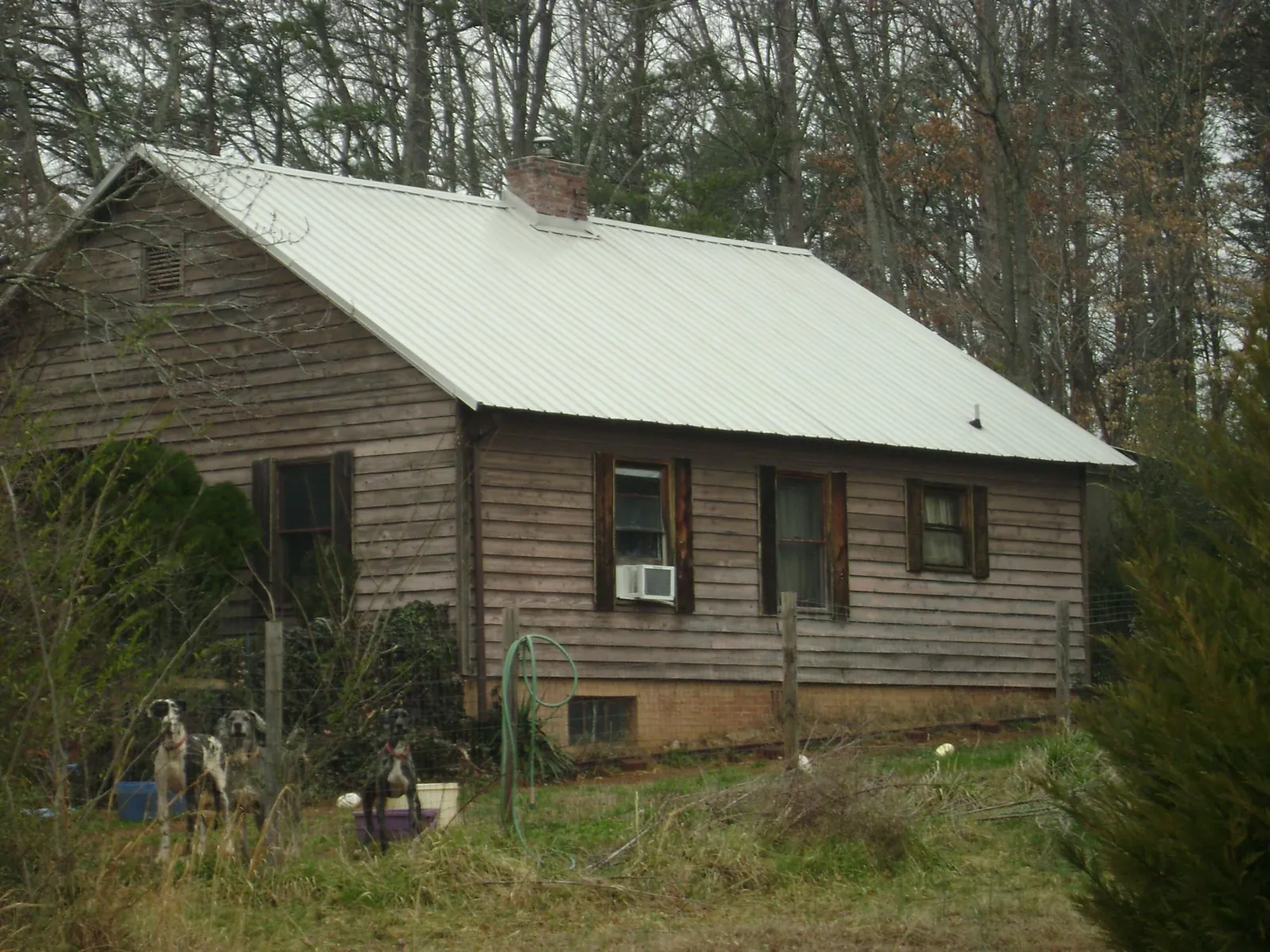 White metal roof on an old wood sided farmhouse, from a Metal Roof Installation job in Randle